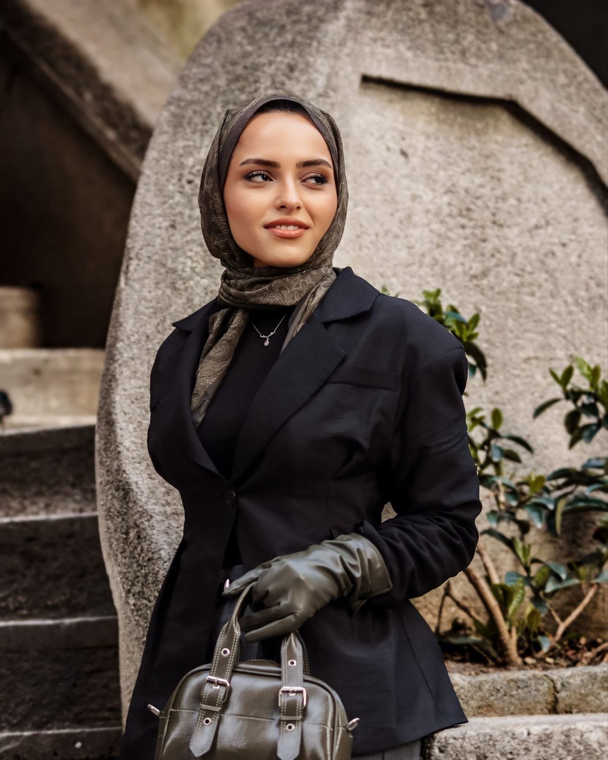 Siyah blazer, haki desenli ipek şal ve haki deri çantayla kombin